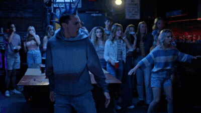 A Man With A Blue Mohawk Stands In Front Of A Sign That Says Connor St. GIF