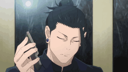 A Man With A Bun Holds A Cell Phone In His Hand GIF