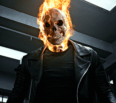 A Man With A Burning Skull On His Head Is Wearing A Leather Jacket GIF