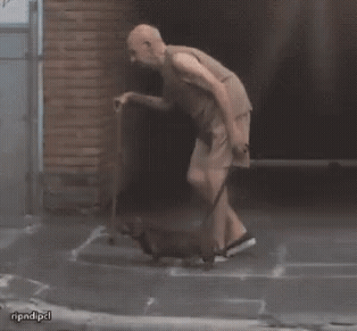 A Man With A Cane Is Walking A Small Dog While Another Man Watches GIF