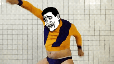 A Man With A Cartoon Face On His Face Is Dancing In Front Of A White Tiled Wall GIF