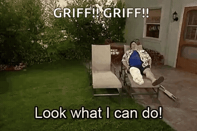 A Man With A Cast On His Leg Is Laying On A Lawn Chair In A Yard . GIF