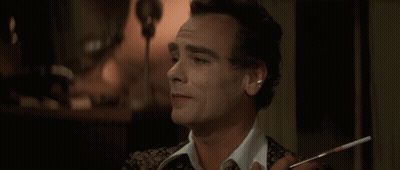 A Man With A Cigarette In His Hand Looks At Something GIF