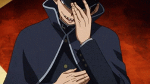 A Man With A Cross On His Hat Is Covering His Face GIF