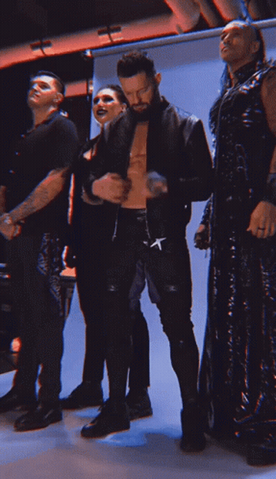 A Man With A Cross On His Pants Is Standing With Other People GIF
