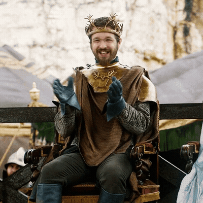 A Man With A Crown On His Head Is Sitting On A Chair GIF