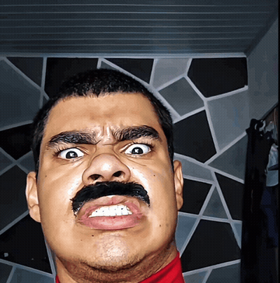 A Man With A Fake Mustache On His Face Makes A Funny Face GIF