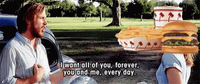A Man With A Hamburger On His Head Talks To A Woman GIF