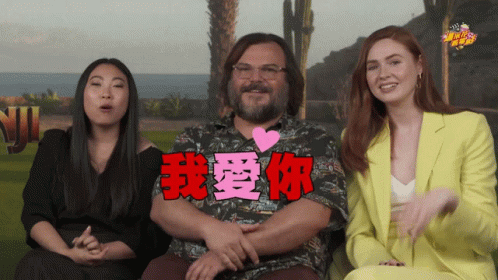 A Man With A Heart On His Chest Is Surrounded By Two Women And A Sign That Says " I Love You " GIF