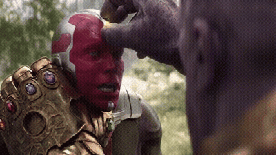 A Man With A Helmet And A Glove With Gems On It Is Being Touched By Another Man GIF