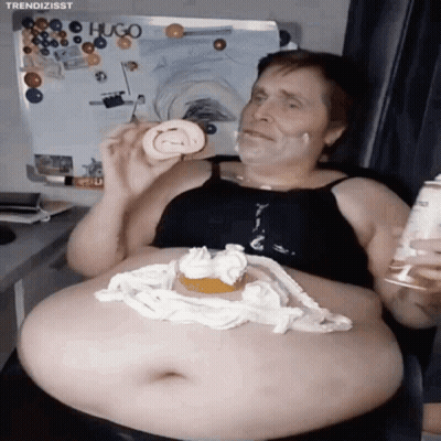 A Man With A Huge Belly Is Eating A Cake With Whipped Cream On It GIF