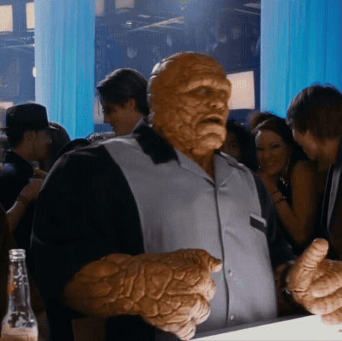 A Man With A Huge Hand Stands In A Crowd GIF