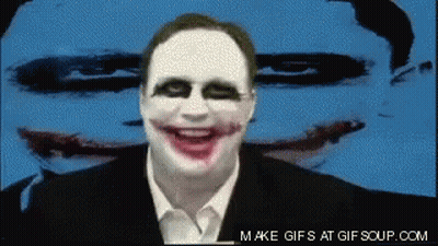 A Man With A Joker Face Painted On His Face Is Smiling In Front Of A Blue Background GIF