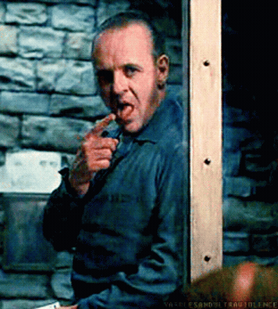 A Man With A Knife In His Mouth Is Standing In Front Of A Brick Wall .. GIF