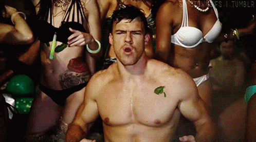 A Man With A Leaf Tattoo On His Chest Is Surrounded By Women In Bikinis .. GIF
