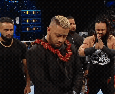 A Man With A Lei Around His Neck Is Standing In A Ring With Other Men GIF
