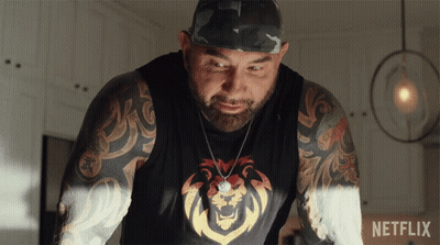 A Man With A Lion On His Shirt Is Standing Next To A Netflix Sign GIF