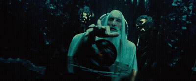 A Man With A Long White Beard Is Holding A Clock In His Hand . GIF