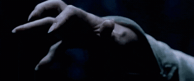 A Man With A Long White Beard Is Holding Something In His Hand In A Dark Room GIF