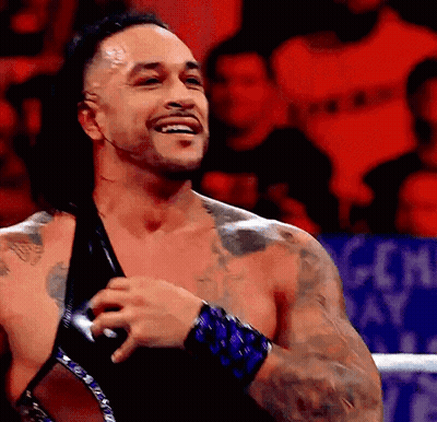 A Man With A Lot Of Tattoos Is Smiling In A Ring GIF