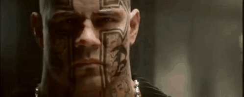 A Man With A Lot Of Tattoos On His Face And Neck . GIF