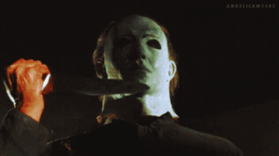 A Man With A Mask Holds A Knife To His Neck And The Words Angelicamyers Are Above Him GIF