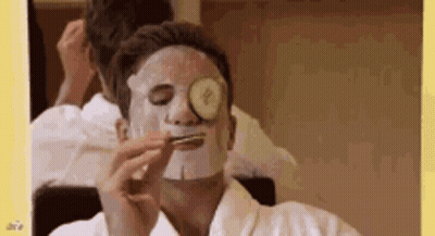 A Man With A Mask On His Face And A Cucumber On His Eye . GIF
