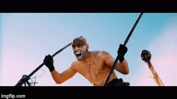 A Man With A Mask On His Face Is Holding A Spear And A Skull In His Hand .. GIF