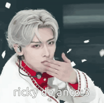 A Man With A Microphone On His Ear Is Blowing A Kiss While Wearing A White Coat . GIF