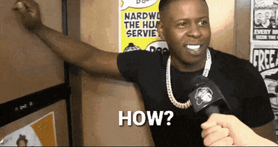 A Man With A Microphone Says How In Front Of A Wall With Posters On It GIF