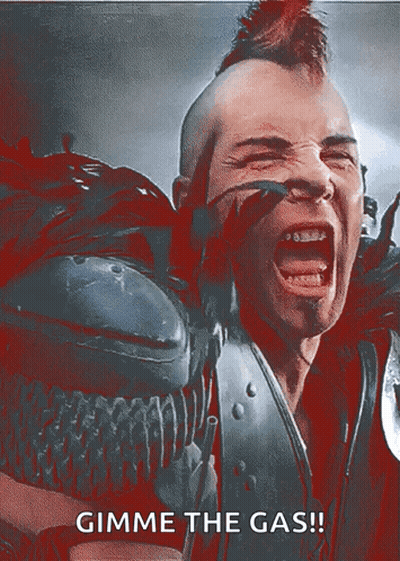 A Man With A Mohawk Is Screaming With The Words Gimme The Gas GIF