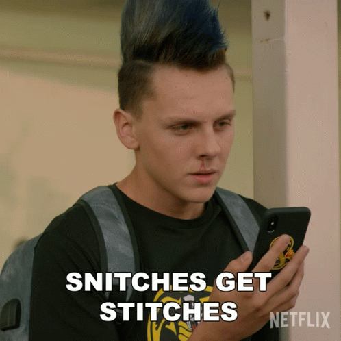 A Man With A Mohawk Looks At His Phone And Says Snitches Get Stitches Netflix GIF