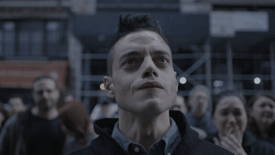 A Man With A Mohawk Looks Up At Something In The Sky GIF