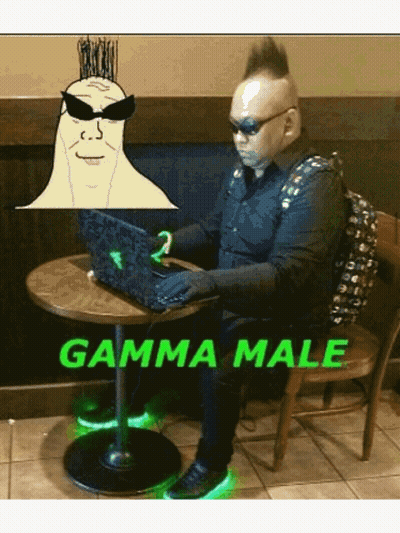A Man With A Mohawk Sits At A Table With A Laptop And The Words Gamma Male GIF