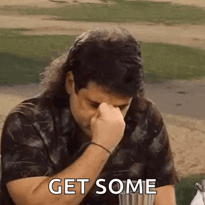 A Man With A Mullet Is Covering His Nose With His Fist . GIF