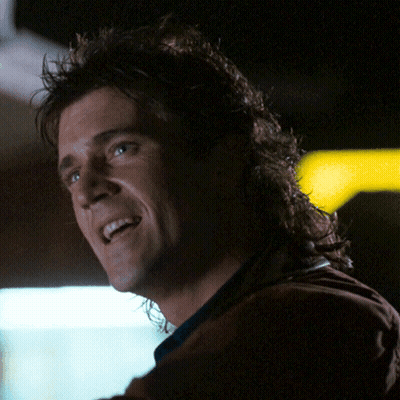 A Man With A Mullet Is Smiling And Looking Up GIF
