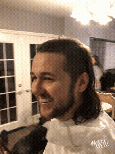 A Man With A Mullet Is Smiling In A Motion Stills Photo GIF