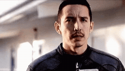 A Man With A Mustache And A Leather Jacket Is Looking At The Camera . GIF