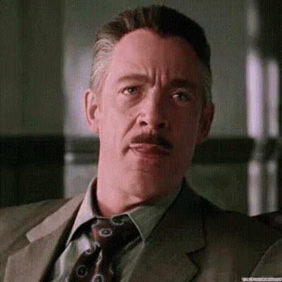 A Man With A Mustache And A Suit And Tie Is Making A Funny Face . GIF