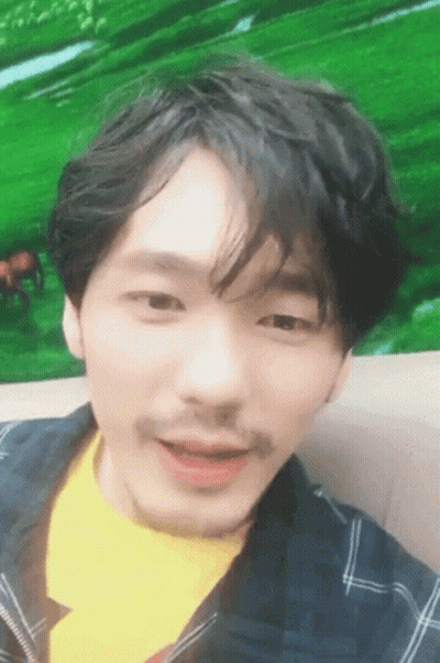 A Man With A Mustache And A Yellow Shirt Is Smiling GIF