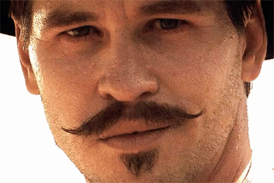 A Man With A Mustache And Beard Looks At The Camera GIF