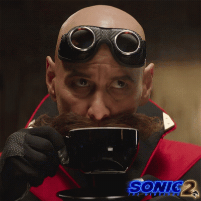 A Man With A Mustache And Goggles Is Drinking From A Cup With Sonic 2 Written On The Bottom GIF