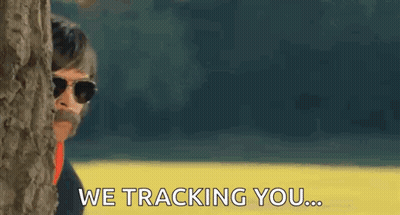 A Man With A Mustache And Sunglasses Is Peeking Out From Behind A Tree And Says We Tracking You GIF