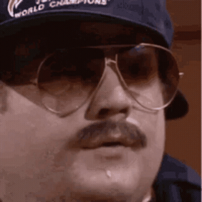 A Man With A Mustache And Sunglasses Is Wearing A Baseball Cap And Sunglasses . GIF