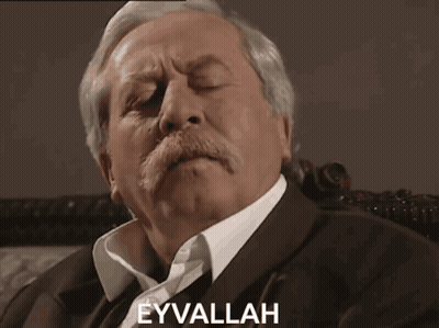 A Man With A Mustache Has The Word Eyvallah Written On His Face GIF