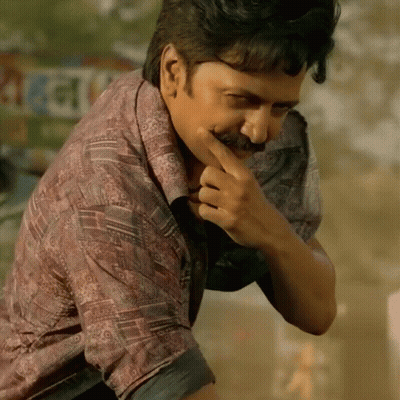A Man With A Mustache Is Covering His Mouth With His Hand In Front Of A Sign That Says ' Rani ' GIF