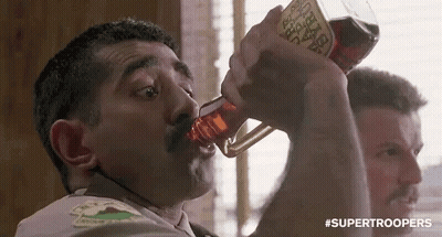 A Man With A Mustache Is Drinking From A Bottle With A Label That Says ' Supertroopers ' On It . GIF