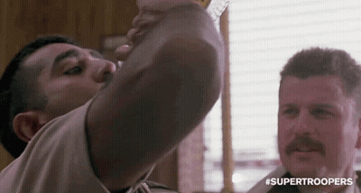 A Man With A Mustache Is Drinking From A Glass . GIF