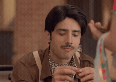 A Man With A Mustache Is Eating A Snack GIF