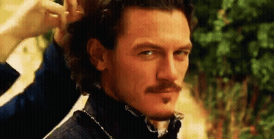 A Man With A Mustache Is Getting His Hair Done . GIF